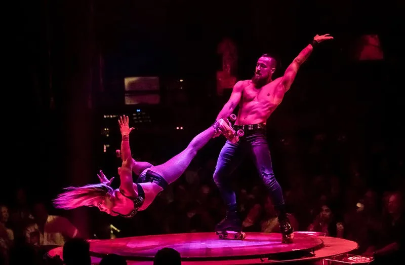 Absinthe roller skate acrobats perform on a circular platform under pink lights at the Spiegeltent, Caesars Palace Las Vegas