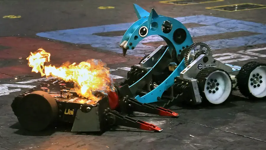 Big Blue Saw robot attacking a burning opponent during BattleBots Destruct-A-Thon live show at BattleBots Arena Las Vegas