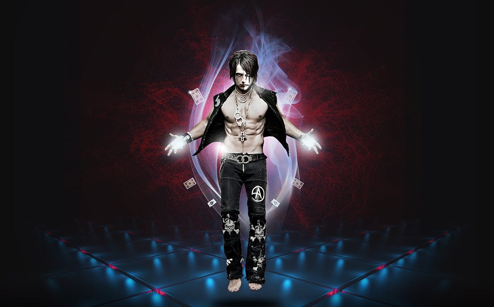 Criss Angel levitating barefoot in gothic black outfit with playing cards floating around him — iconic MINDFREAK promotional photo at Planet Hollywood Las Vegas