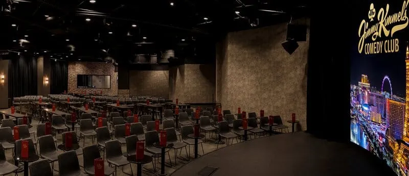 Interior of Jimmy Kimmel's Comedy Club showroom with rows of seating facing the stage screen