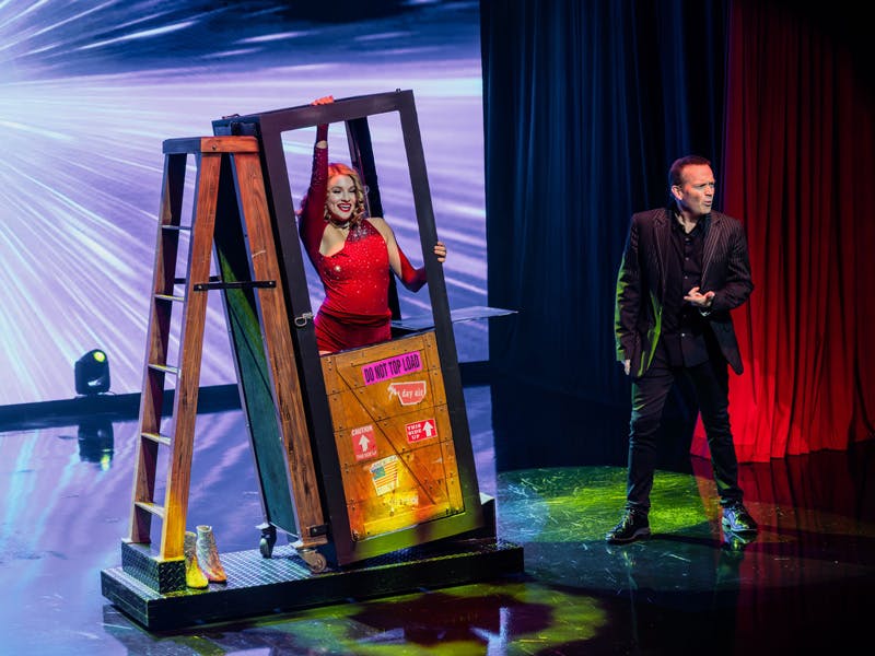 Nathan Burton performing a large-scale illusion with a showgirl in a red dress on stage at the Nathan Burton Theater, Las Vegas