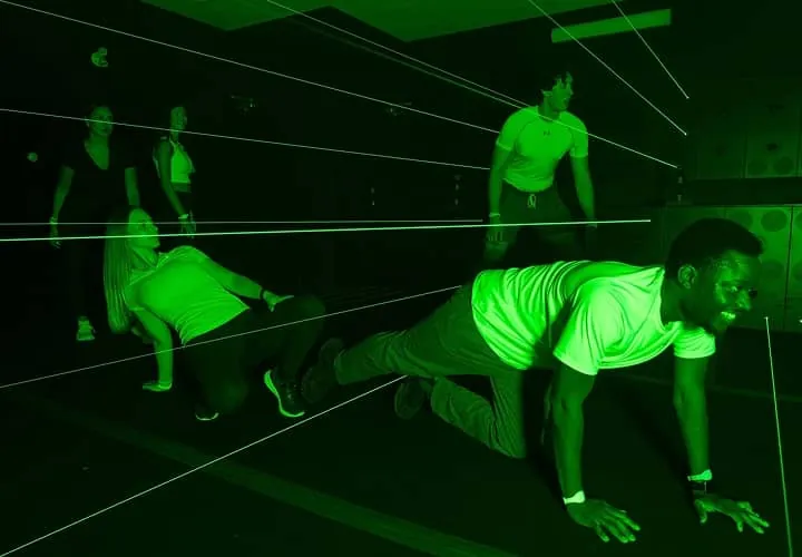 Players race through a green laser-grid arena at Activate