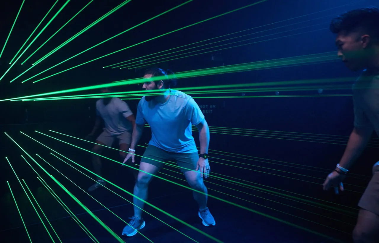 Players dodge through a green laser-grid arena at Activate
