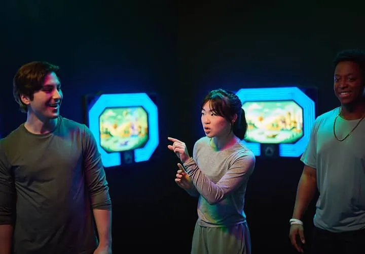 A group strategizes in front of lit-up game screens inside Activate