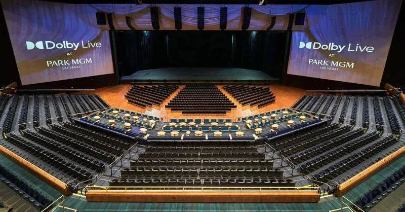 Interior of Dolby Live at Park MGM — sweeping blue theater seating facing a wide stage beneath massive screens, one of Las Vegas's premier entertainment venues