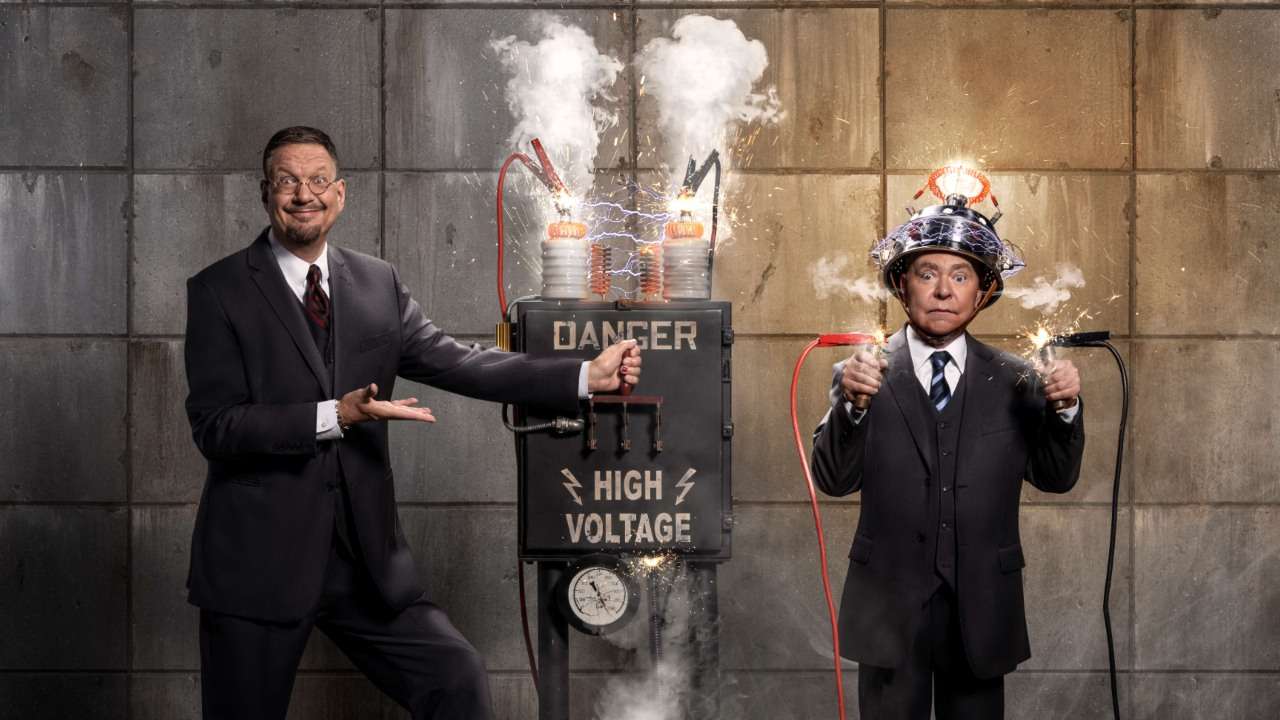 Penn Jillette and Teller in a dramatic promotional photo with a sparking Danger High Voltage machine — Penn & Teller Las Vegas magic show at the Rio Hotel