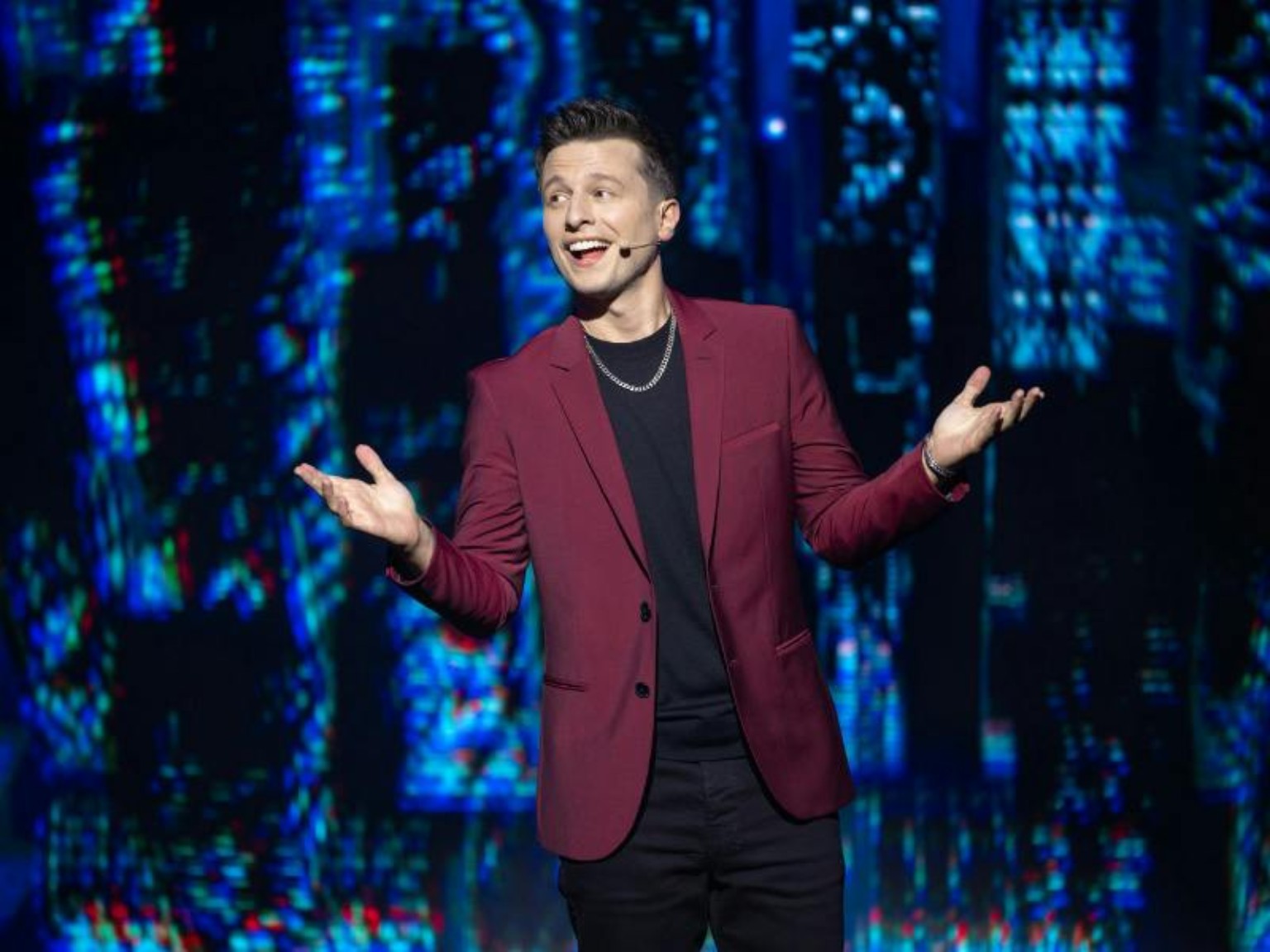 Mat Franco performing in a burgundy jacket during his Las Vegas magic show