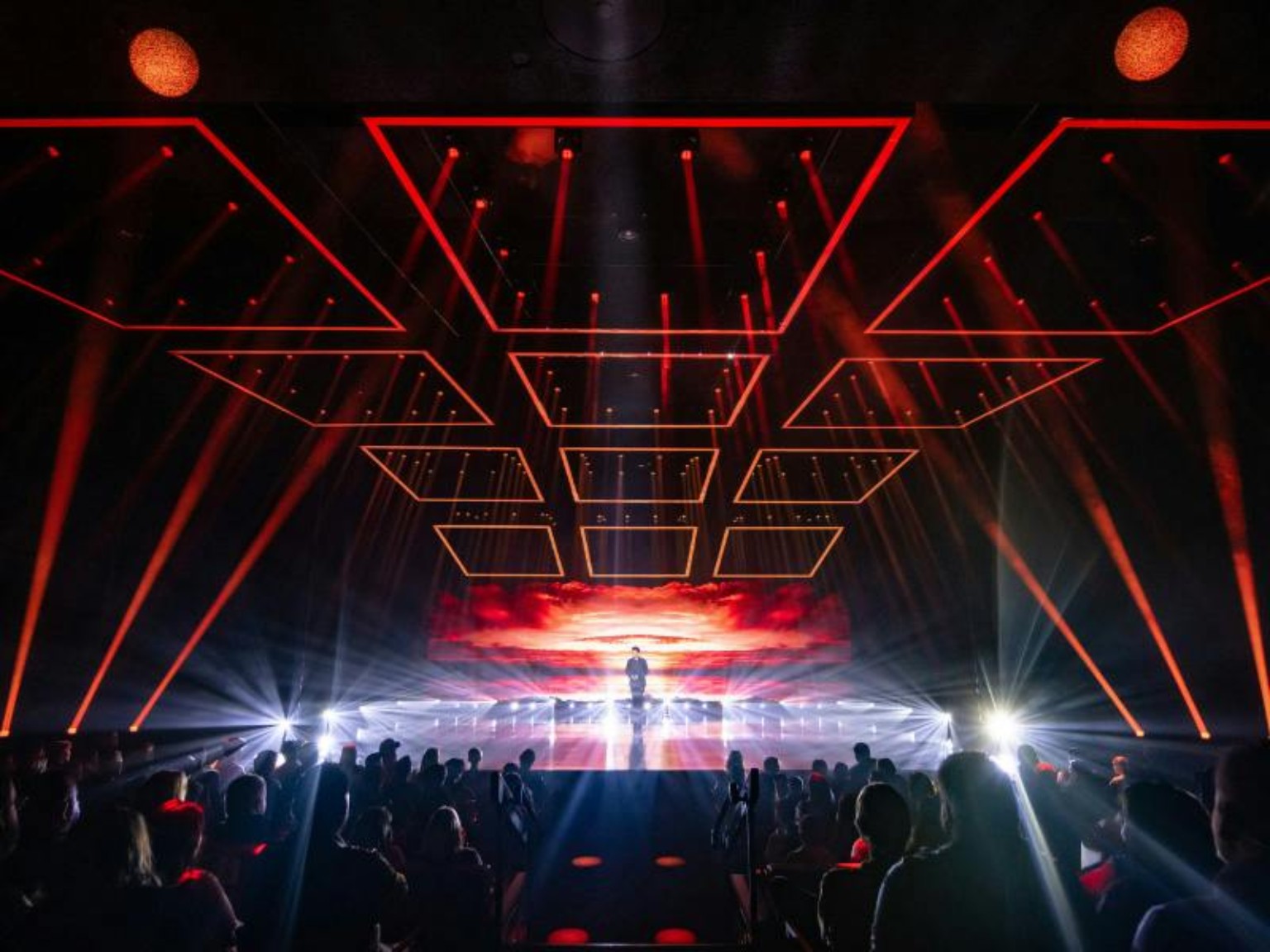 Mat Franco performing on a wide red-lit stage at The LINQ in Las Vegas